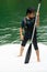 Asian boy wearing life jackets paddling on an inflatable boat in Kenyir Lake, Malaysia