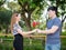 Asian Boyfriend offering his girlfriend a bunch of roses in the park.