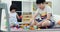 Asian brother and sister playing plastic block together at home with smile face.