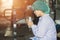 Asian Burmese young woman labor worker sit and relax, playing cell phones, waiting for work shifts in food hygiene factory