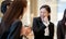 Asian business people talking and laughing in office building. Young businessman and businesswoman colleague talk to each other du