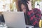 An Asian business woman with feeling stressed and tired , close her eyes while using laptop on glass table