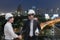 Asian businessman shake hand with engineer architect professional wearing safety helmet and holding construction roll plan for