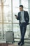 An Asian businessman is using a smartphone to get in business while waiting for a trip in the airport.