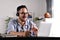 Asian businessman wearing headset on video call with clients on laptop. Young Asian man in glasses giving online educational class