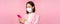 Asian businesswoman in medical face mask using mobile phone. Japenese saleswoman, corporate lady in suit, holding