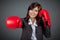 Asian businesswoman punch with boxing glove focus on the glove