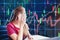 Asian businesswoman sitting on working space and looking the Stock market exchange information and Trading graph