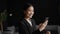 Asian businesswoman using phone gesturing yes celebrating success in office