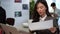 Asian businesswomen analysis documents in office.
