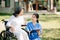 Asian careful caregiver or nurse and the happy patient in a wheelchair are walking in the garden. to help and encourage and rest