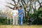 Asian careful caregiver or nurse and the happy patient in a wheelchair are walking in the garden to help and encourage and rest