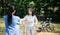 Asian careful caregiver or nurse and the happy patient in a wheelchair are walking in the garden to help and encourage and rest