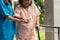 Asian careful caregiver or nurse hold patient hand and encourage patient, walking in garden. Concept of happy retirement with care