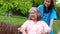 Asian careful caregiver or nurse taking care of the patient in a wheelchair.  Concept of happy retirement with care from a