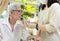 Asian caregiver take care of senior woman give drinking water from a glass,feeding water using a straw to prevent choking at