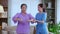 Asian caregiver woman or nurse training senior woman stretch arm for exercise while physical therapy and rehabilitation.