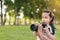 Asian caucasian mixed race girl learning to take a image from camera, Father taught her daughter, at outdoor park