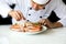 Asian chef preparing and decorating grilled crab seafood meal with vegetable.