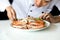 Asian chef preparing and decorating grilled crab seafood meal wi