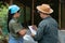 Asian Chicken Farmer is teaching and examining the breeding conditions to his wife of laying hens to obtain clean and quality hen