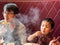 Asian child boy eating delicious jade noodle on table in restaurant with father