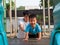 Asian child boy playing in playground together with dad in happy family time. Father support son with love and care