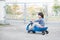 Asian child driving blue toy car outdoors