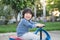 Asian child driving blue toy car outdoors