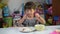 Asian child eating food breakfast at the table at home three or four years old