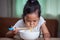 Asian child girl eating delicious instant noodles with chopsticks for her lunch in the house