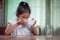 Asian child girl eating delicious instant noodles and drinking soup from bowl for her lunch in the house