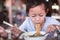 Asian child girl eating noodles with chopstick in restaurant