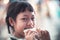 Asian child girl eating some bread with smile and happy