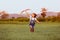 Asian child girl and father with a kite running and happy on meadow in summer in nature