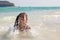 Asian child girl having fun to play water in the beautiful sea in summer vacation