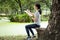 Asian child girl hobby is drawing pictures with white blank sheet of paper in clipboard, sitting in nature, beautiful female
