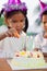 Asian child girl lighting candle on birthday cake in birthday party