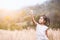 Asian child girl playing with toy wooden airplane in the barley field at sunset time with fun