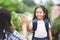 Asian child girl with school bag and her mother making hi five