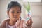 Asian child girl showing her recycle flower pot after finish painting on plastic bottle with watercolor.