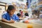 Asian child girl and sister wearing protection mask making fusible beads thermo mosaic in pegboard that is a toy to develops the