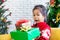 Asian child girl surprise with gift and holding beautiful gift boxes in hand on Christmas celebration