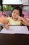 Asian child girl use Pencil write letters on the book.