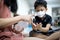 Asian child girl is using an alcohol antiseptic gel to clean her brother`s hands,Kid boy wearing a mask learning to wash hands