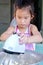 Asian child girl is using an electric beater to beat the dough to make pastries.