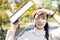 Asian child girl walking outdoor protects from the sunlight UV rays with her book,female teenager worried about hot strong sunburn