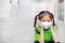 Asian child girl wearing a protection mask while outside to against PM 2.5 air pollution with pointing up in Bangkok city.