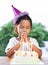 Asian child girls make folded hand to wish the good things for her birthday in birthday party