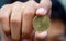 Asian child hand holding a Fifty Halalas Riyal coin, Saudi Arabia money, selected focus